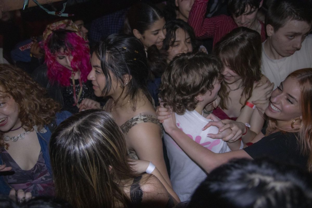 Crowd members dance together during Lovebite's set at The Cosmos in Urbana on Feb. 8.