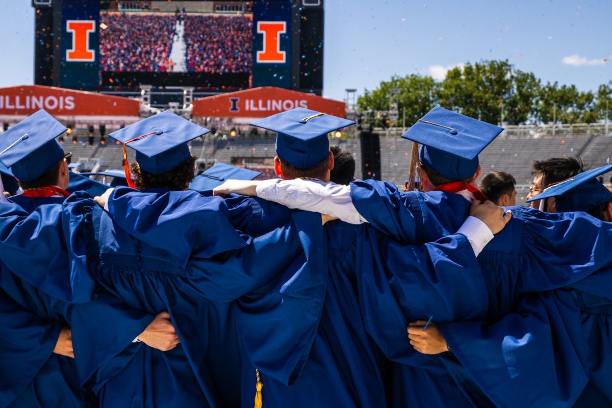Newly graduated Illinois students link arms and sing "Hail to the Orange" to conclude the 2025 Illinois Commencement ceremony on May 17.