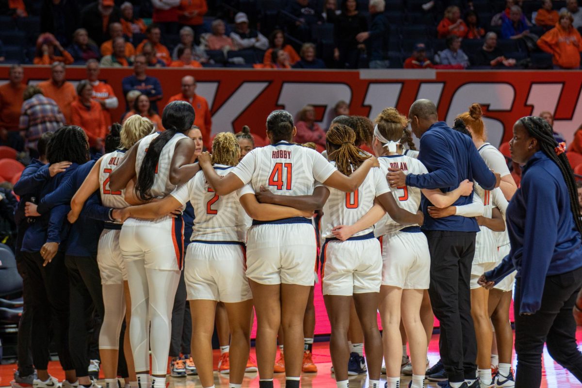 Illini women’s basketball team and staff gather in a team huddle before the second half of the game begins on Oct. 30, 2023.