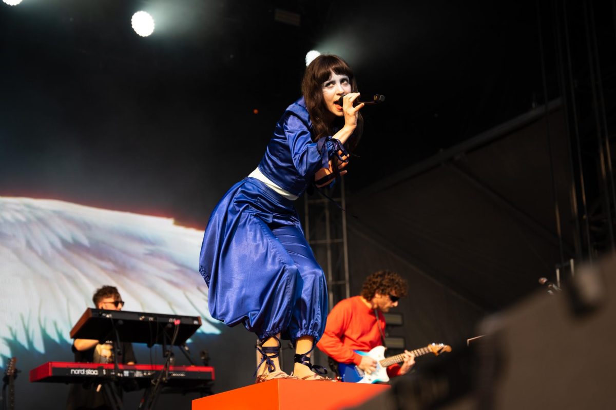 Mica Tenenbaum, lead singer of the band Magdalena Bay, crouches down and looks out across the crowd of her opening day set. Magdalena Bay performed on the Lakeshore stage on day 1 of Lollapalooza, July 31.