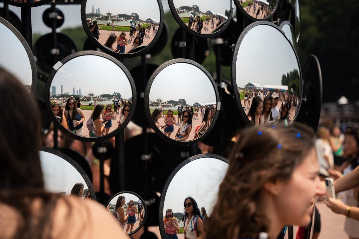 Festival-goers enjoy a mirror tower photo-op, giving panoramic views of downtown Chicago in the background.