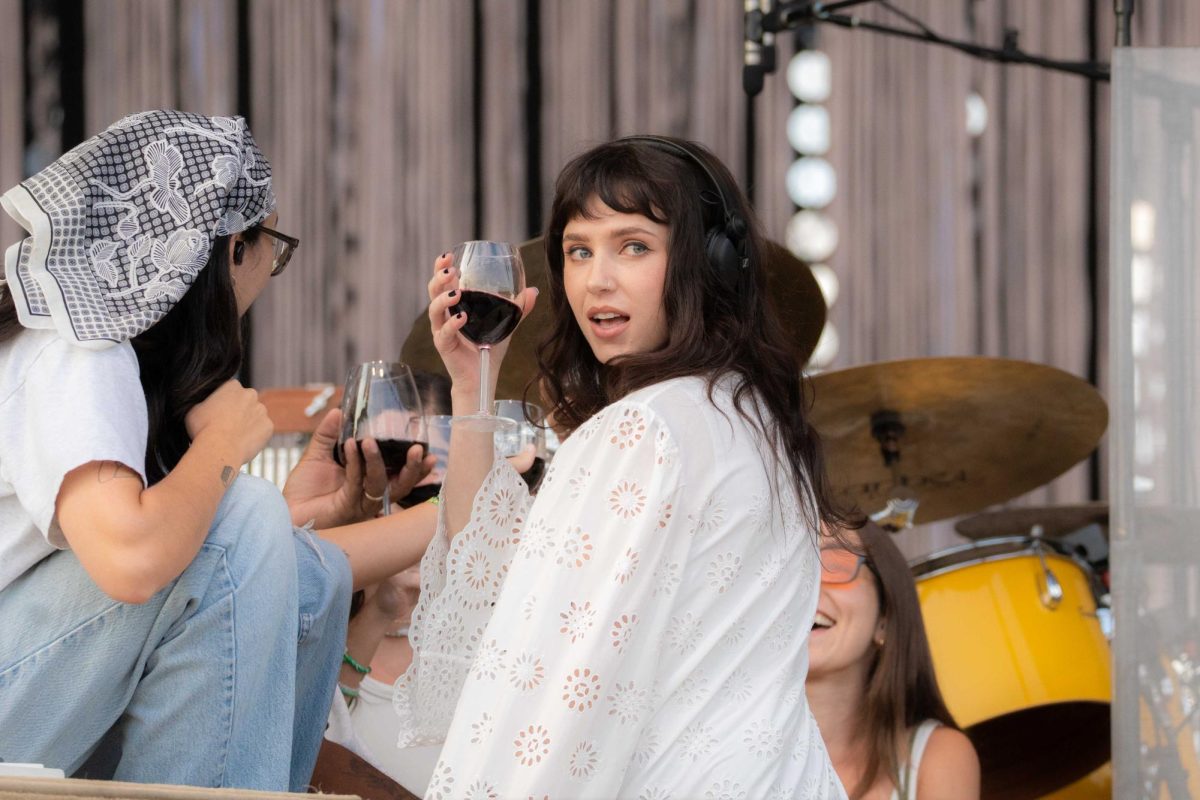 Clairo sits on the Bud Light stage enjoying a glass of wine with her band on Saturday, day 3 of Lollapalooza. As she turns and looks at the crowd, they erupt with screams of adoration.