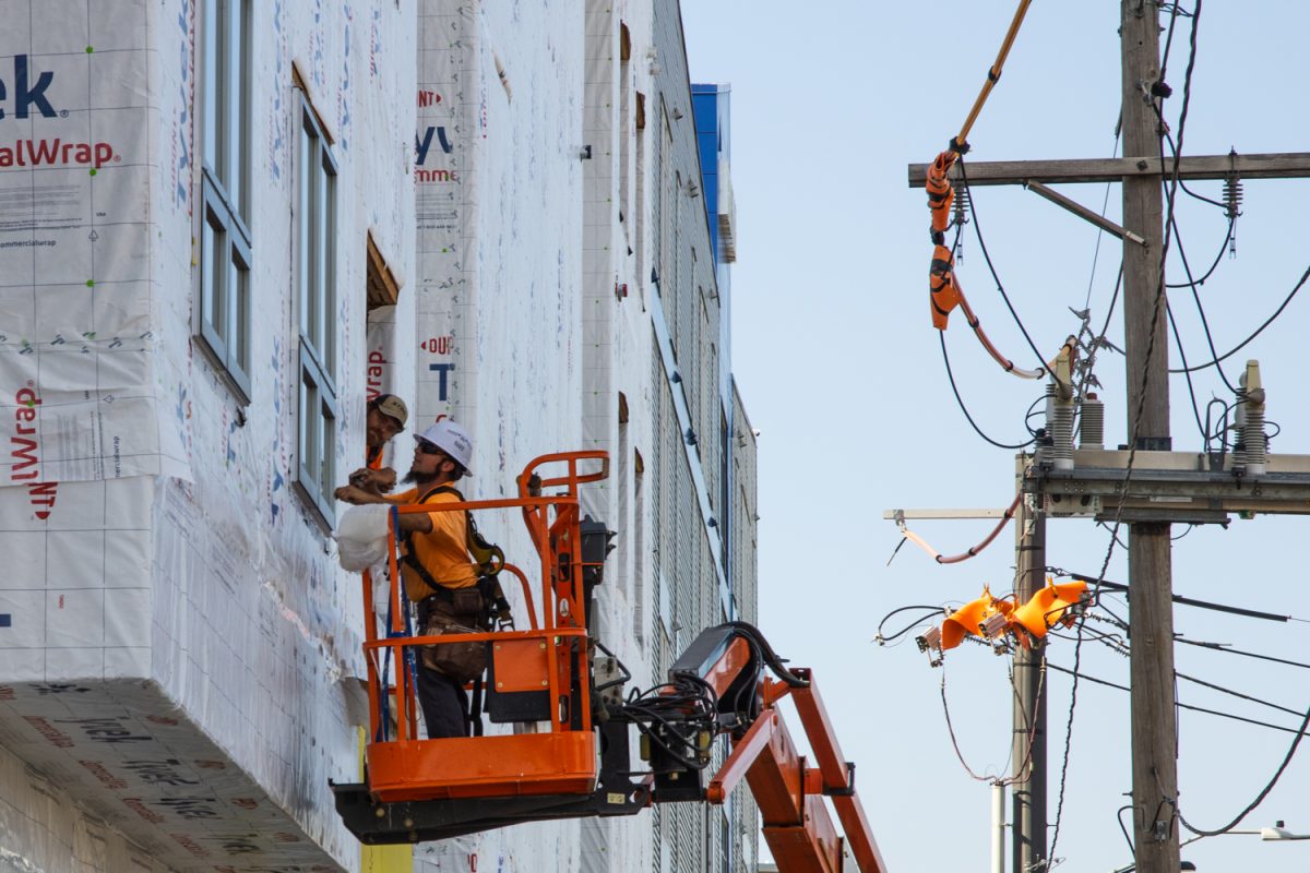 Two construction workers work on the apartment at 60 E. Green St. on Aug. 14.