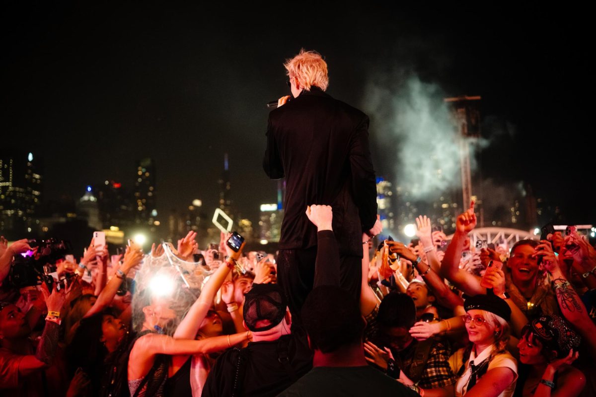 Lead singer of RÜFÜS DU SOL Tyrone Lindqvist stands on the barricade in front of fans during his performance on the T-Mobile stage on Saturday, day 3 of Lollapalooza.