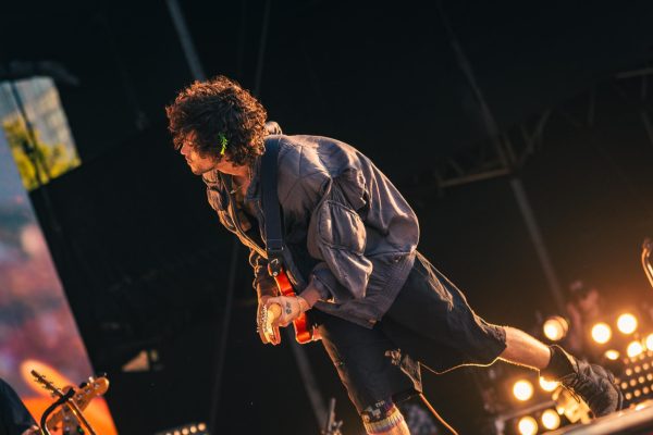 Dominic Fike leans toward his band as he plays at T-Mobile stage Sunday afternoon at Lollapalooza.