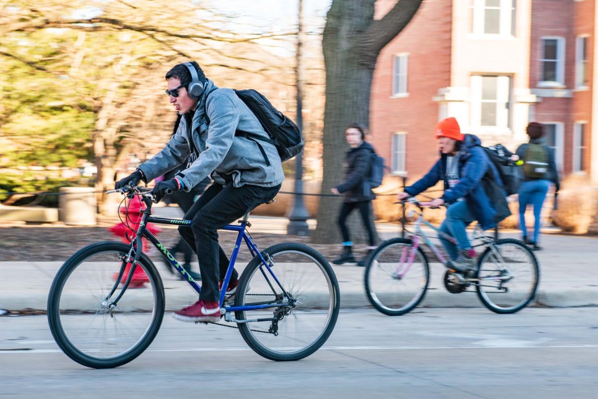 Two students ride bikes up Wright Street after class on Feb. 10, 2023. Champaign County Bike Month begins this month with free events encouraging safe and active transportation across the community. 