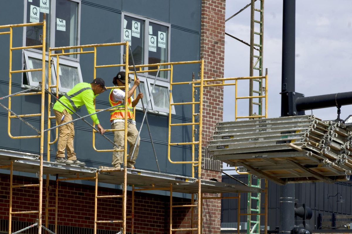 Two construction workers work in the afternoon heat while moving material for the new apartment complex being built on the corner of 60 E. Green St., Champaign, on Sept. 13. Rising tariffs on imported materials have increased costs on imported materials for construction projects across campus. 