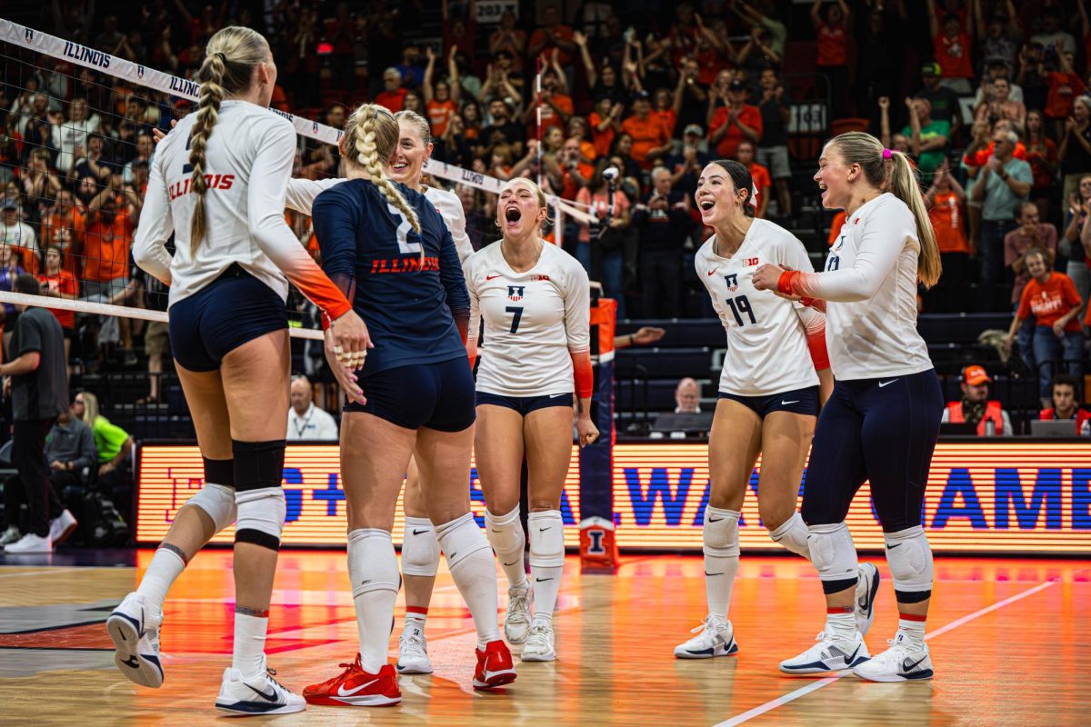 The Illinois volleyball team celebrates the point that would secure them the win over Oregon on Friday. Illinois won the match 3-0.