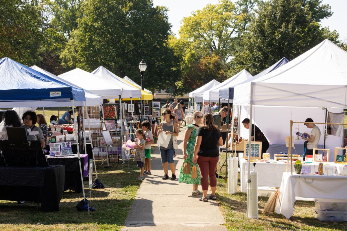 Art vendors and community members gather at West Side Park in Champaign for the West Side Arts Festival hosted by 40 North on Sunday. This year's festival saw 25 vendors selling art pieces of various mediums, including clothing, handmade candles, jewelry, paintings, and printed photos.