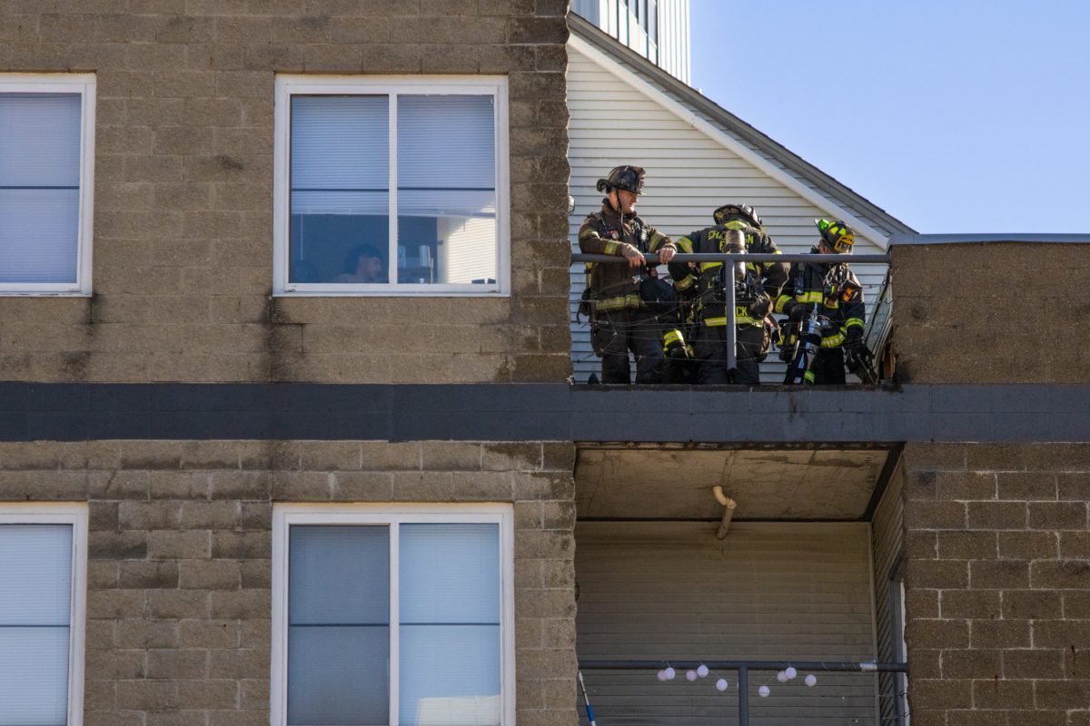 Champaign firefighters clear away debris after a fire on a balcony of a residential apartment located at 303. E Green Street on Sept. 18.