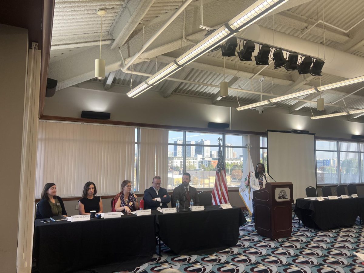 Rep. Carol Ammons stands at the Illinois Terminal alongside panelists Jennifer McCaffrey, Lisa Benson, Danielle Chynoweth, Chris Manson and John Walsh (left to right). The panel discussed cuts to social services and federally funded health insurance. 