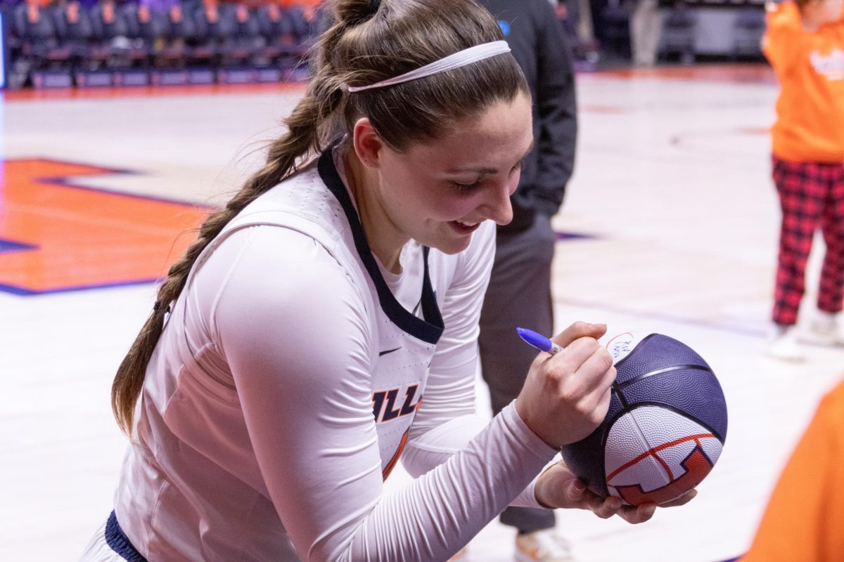 Fifth year forward Kendall Bostic autographs a fan's basketball at the end of the Illinois vs. Northwestern game, in State Farm Center on Feb. 6.