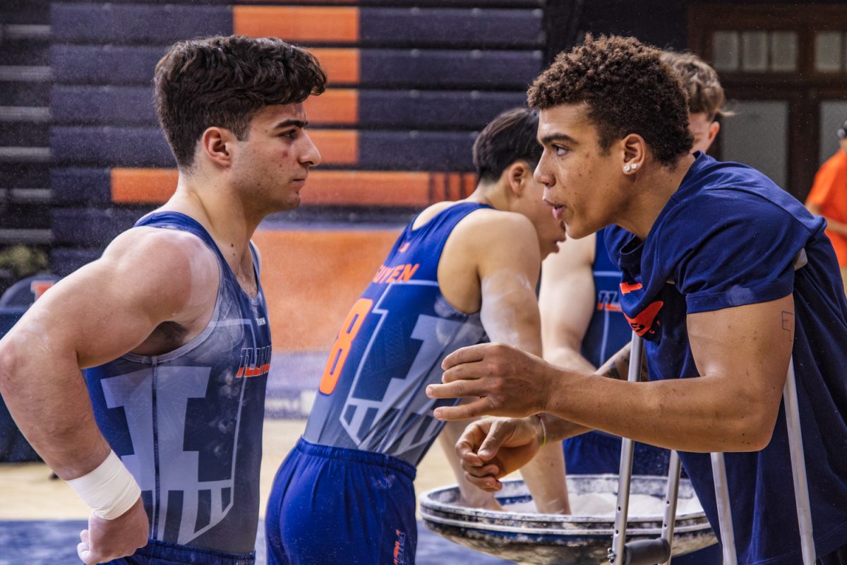 Redshirt fifth year Sam Phillips speaks to sophomore Vahe Petrosyan before he competes on the parallel bars at a meet on March 1. The now graduate student's last season was cut short by an early-season injury.