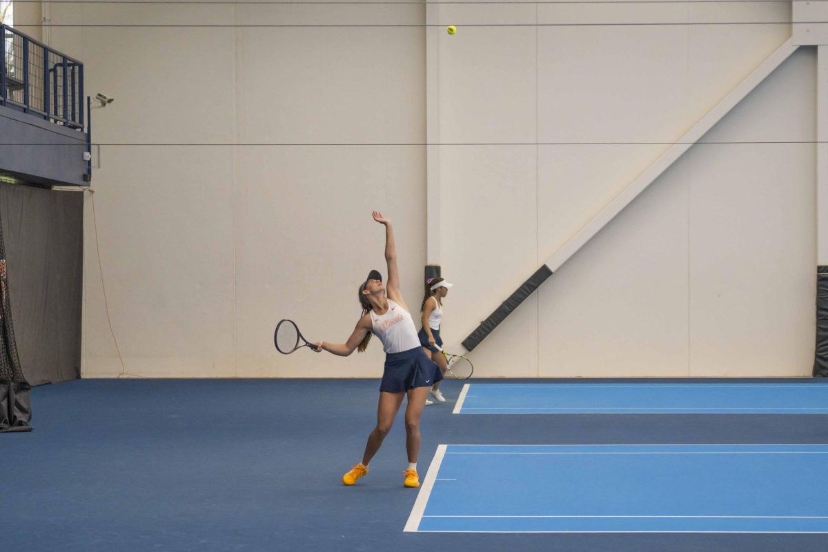 Sophomore McKenna Schaefbauer sends the ball into the air to begin her serve during the Illinois vs. Indiana match on April 12, 2024, in the Atkins Tennis Center.