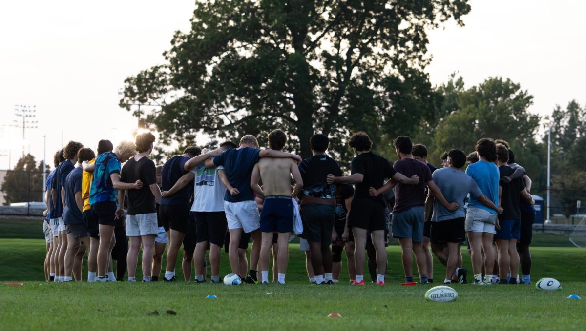 Members of the Illinois men's rugby club join in a huddle at the end of practice on Sept. 30.