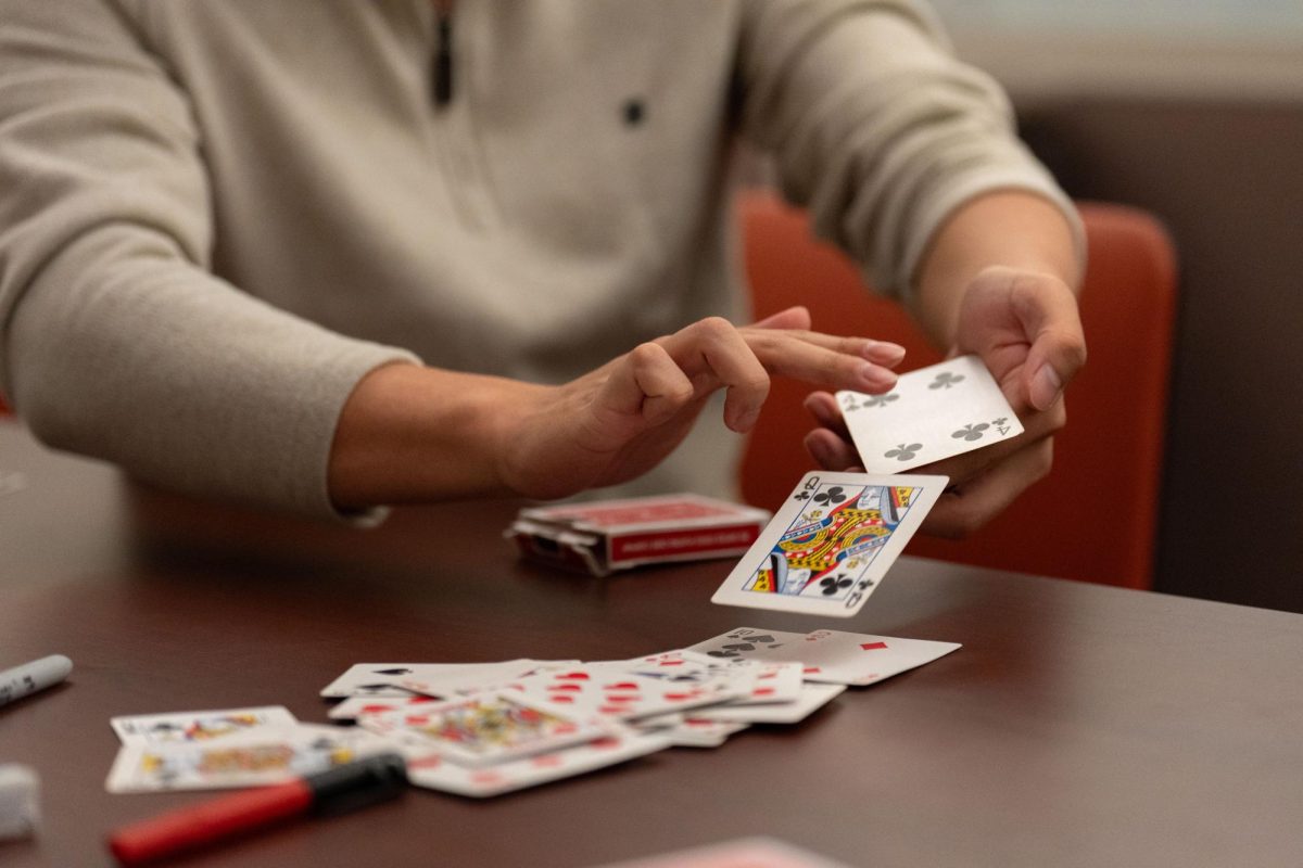 At the IDEA Lab in the Grainger Library basement, the Illini Magic Society is hosts a weekly meeting. Eric Fang, society member, is shuffling cards, demonstrating a classic force.