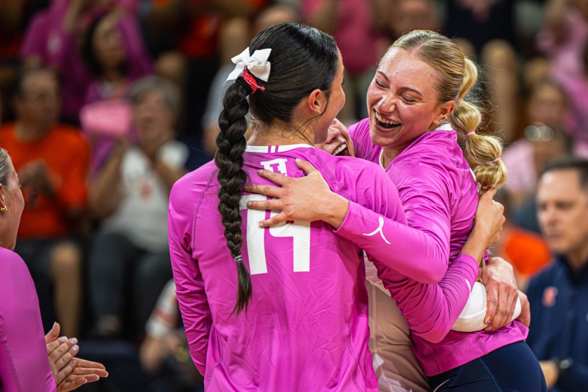 Junior setter Kenna Phelan hugs her teammates after scoring a point during the team’s match against Michigan State on Oct. 5. Illinois would go on to win the match 3-2.