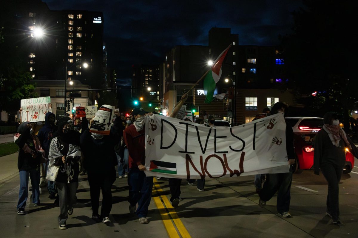 Pro-Palestinian demonstrators march down West Green Street in Urbana on Oct. 7, calling on the University to divest from companies who supply arms to Israel.