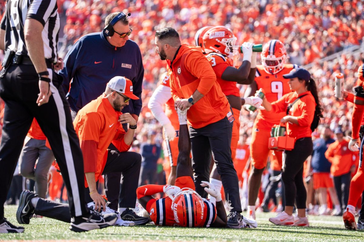 Senior defensive back Torrie Cox Jr. lays on the field and gets stretched out by the Illinois athletic trainer after a big hit in the Illinois vs. Ohio State game on Oct. 9.