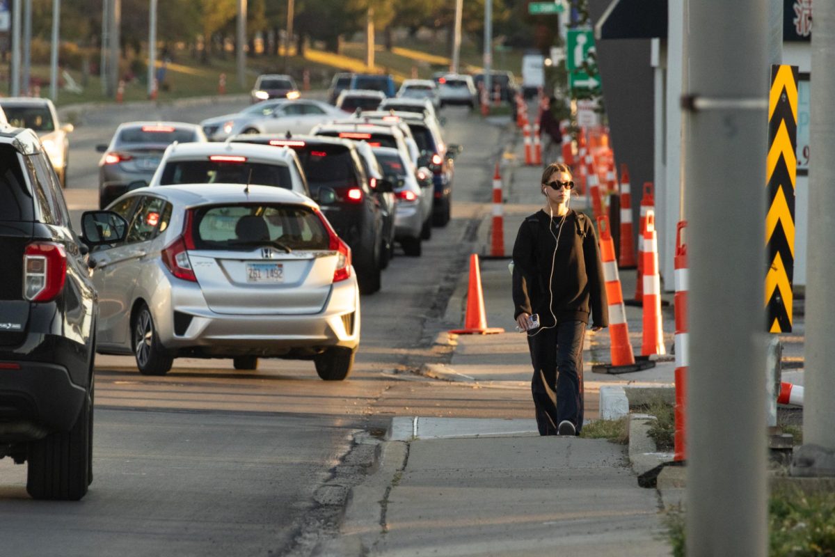A pedestrian walks down South Neil Street during rush hour traffic on Oct. 20. Running concurrent with U.S. 45, this stretch of Neil Street is one of the busiest roads in Champaign County.