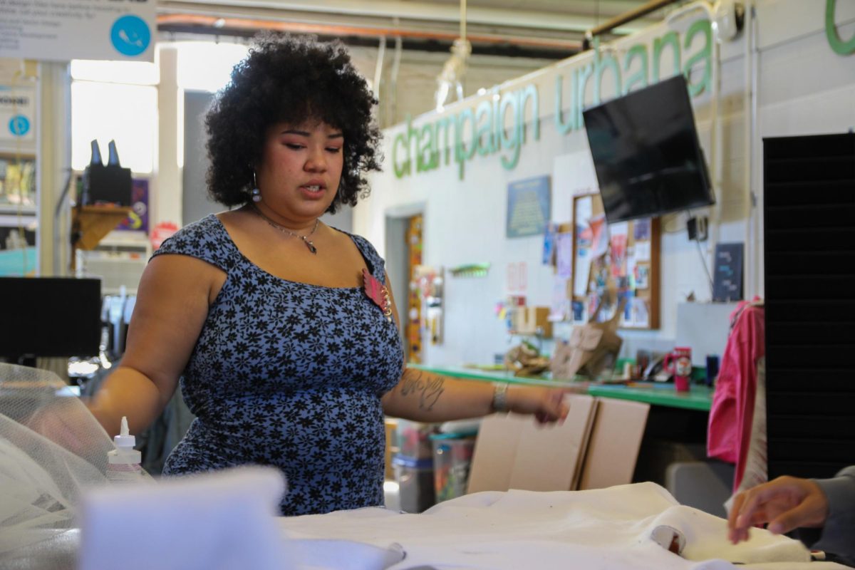 Event coordinator Samantha Jones examines a piece of fabric for event participant’s costume during the DIY costume event held at the Champaign-Urbana Community Fab Lab on Friday. The Community Fab Lab opened the event to all community members, giving them a space to design and create their desired Halloween costumes.