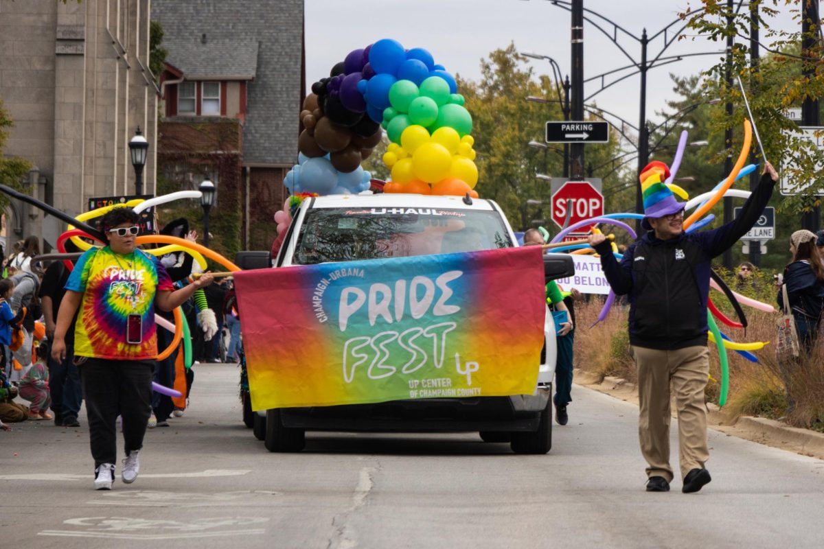 Paradegoers wave to spectators at the front of the C-U Pride Parade on Saturday in downtown Urbana. This year’s parade marked the 15th annual C-U Pride Fest.