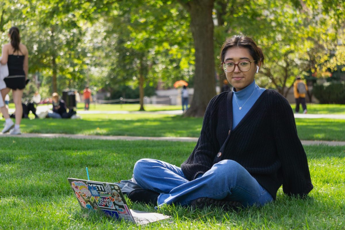 Emma Ortega, junior in LAS, studying on the Main Quad on Oct. 9. She is enjoying the fall weather in front of Foellinger Auditorium.