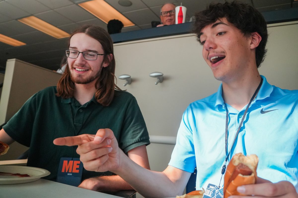 Senior sports reporter Ben Somerville and sports editor Brendan Gallian film a video reviewing the food provided in the press box at Gies Memorial Stadium on Oct. 11.