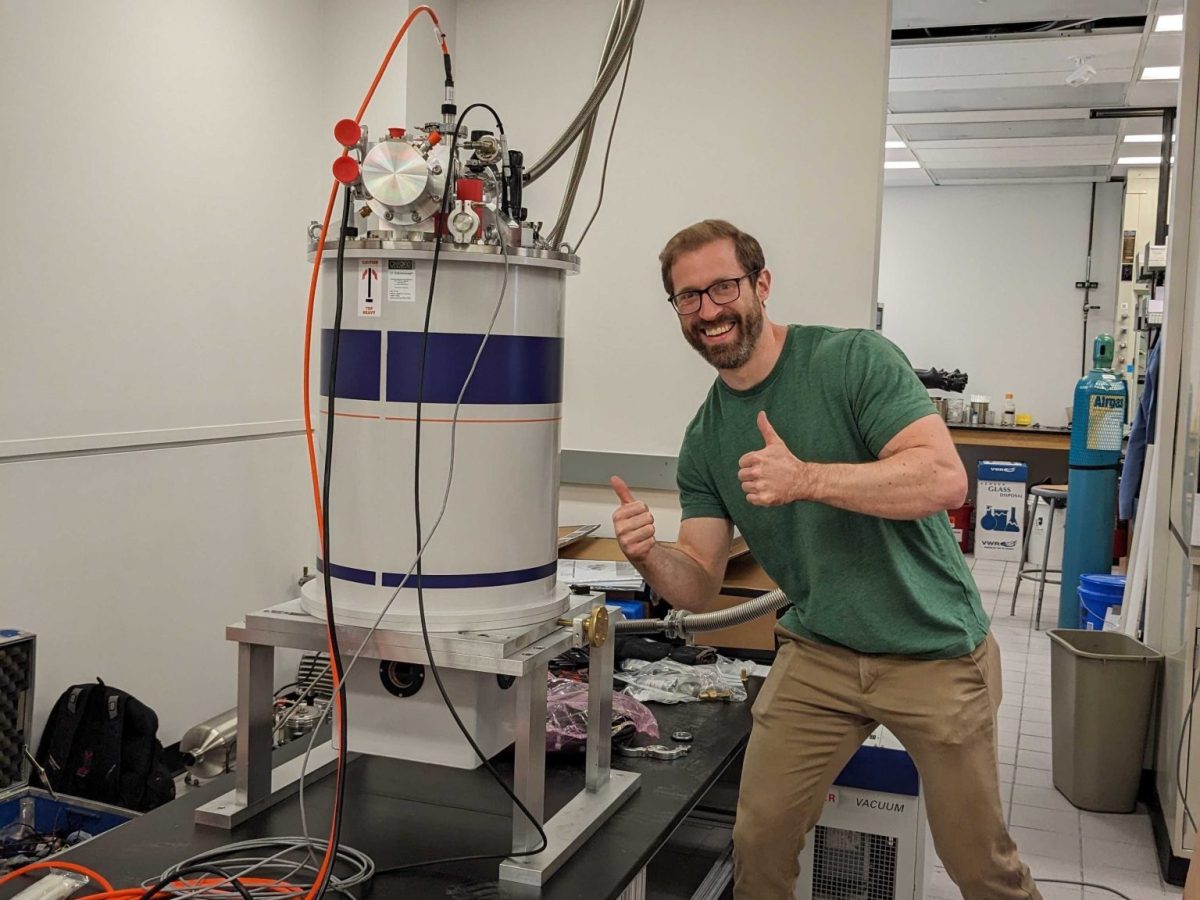 Benjamin Snyder, chemist and professor in LAS, stands with his thumbs up in front of laboratory equipment. The David and Lucile Packard Foundation named Snyder a Packard Fellow last week.