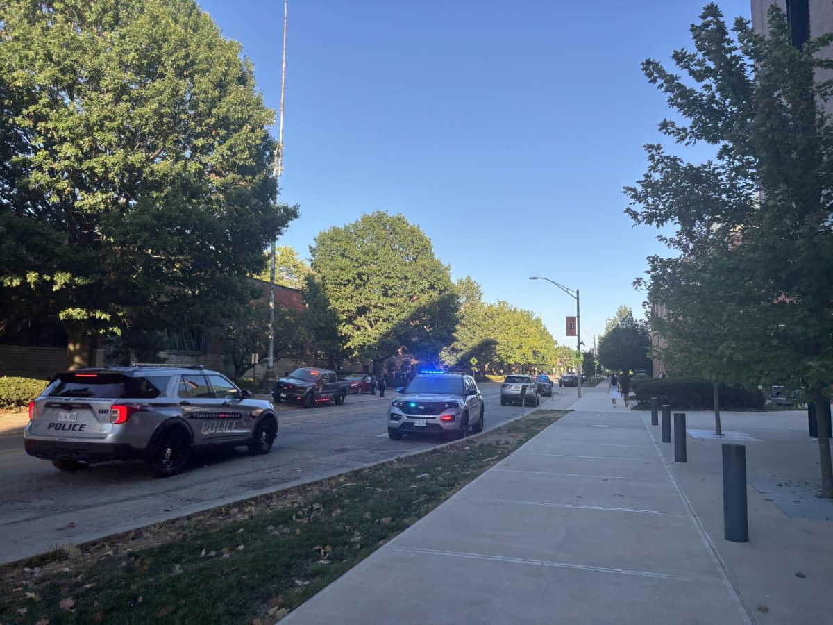 UIPD vehicles stand on the scene of a car struck and injured a bicyclist Sunday afternoon. UIPD said the bicyclist was taken to a hospital for treatment. 