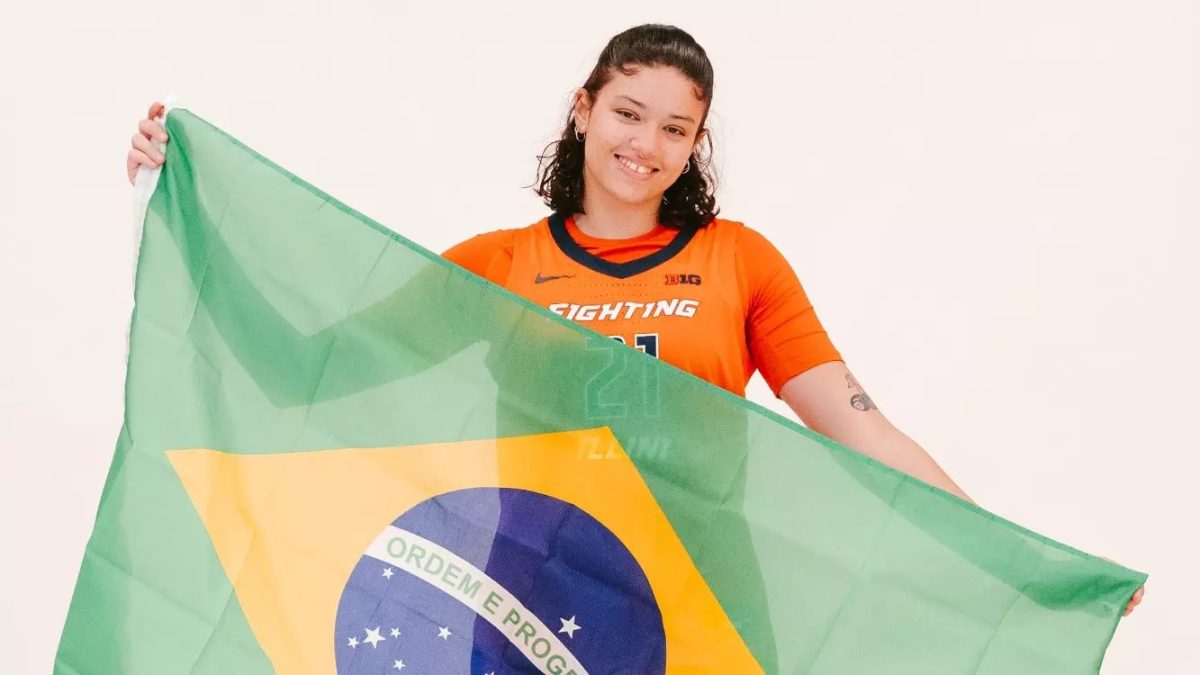 Manuella Alves, freshman forward on the Illinois women's basketball team holds up the flag of Brazil, her home country.