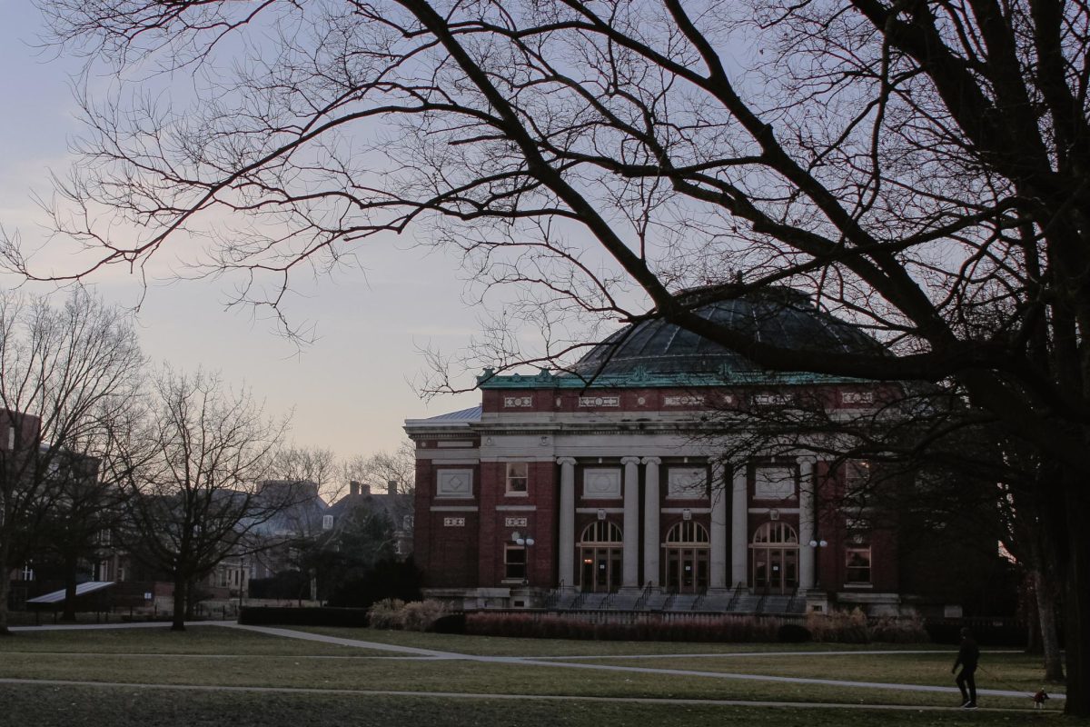 A person walks a dog past Foellinger Auditorium on the Main Quad on Feb. 5, 2024.