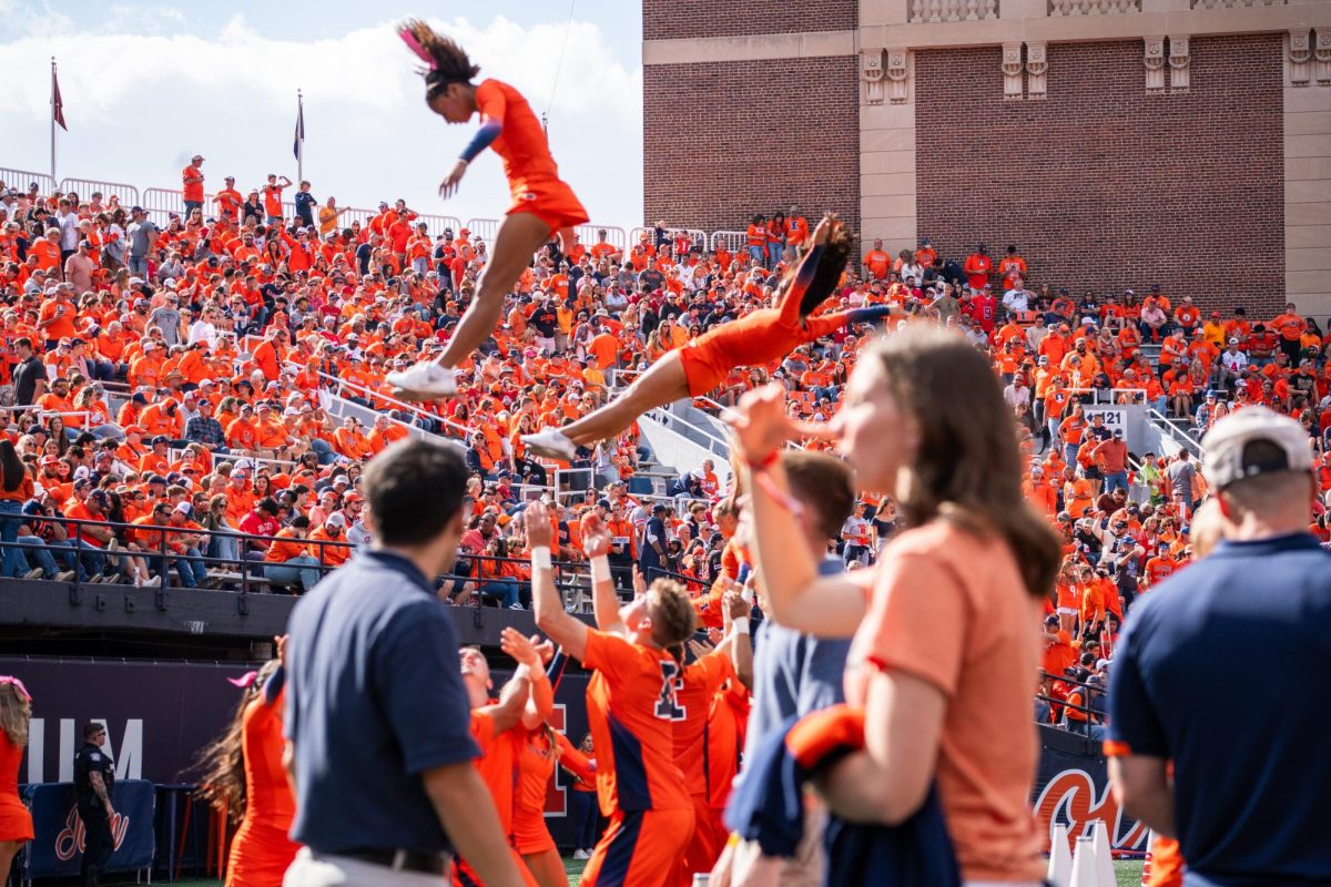 The crowd at the Illinois vs. Rutgers football game watch as cheerleaders throw each other into the air on Nov. 1.
