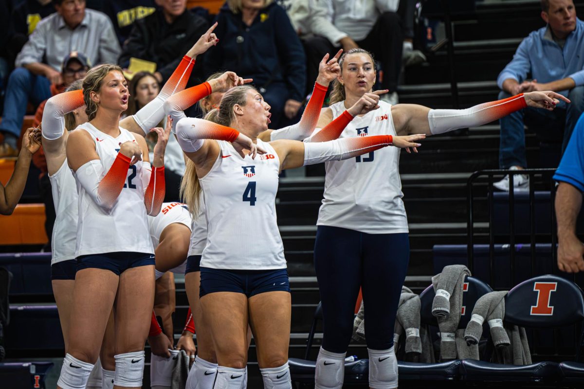 Several Illini, including senior setter Bianca May (#4) point from the sideline during the team’s match against Michigan on Oct. 25. 