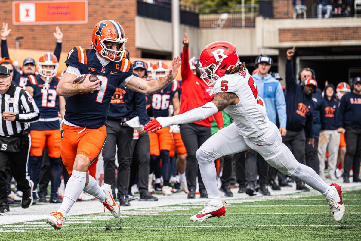 Senior quarterback Luke Altmyer reaches out for the stiff-arm during the Illinois vs. Rutgers game on Nov. 1. Illinois would go on to win the game 35-13.