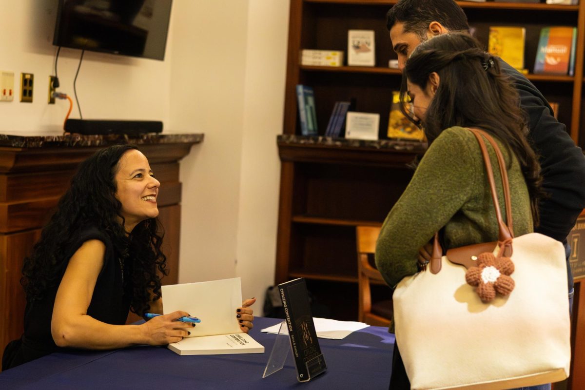 Rana Khoury, assistant professor of political science and author, signs copies of her book "Civilizing Contention: International Aid in Syria's War," after a book talk, that community members could purchase at the Illini Union Bookstore on Nov. 5.