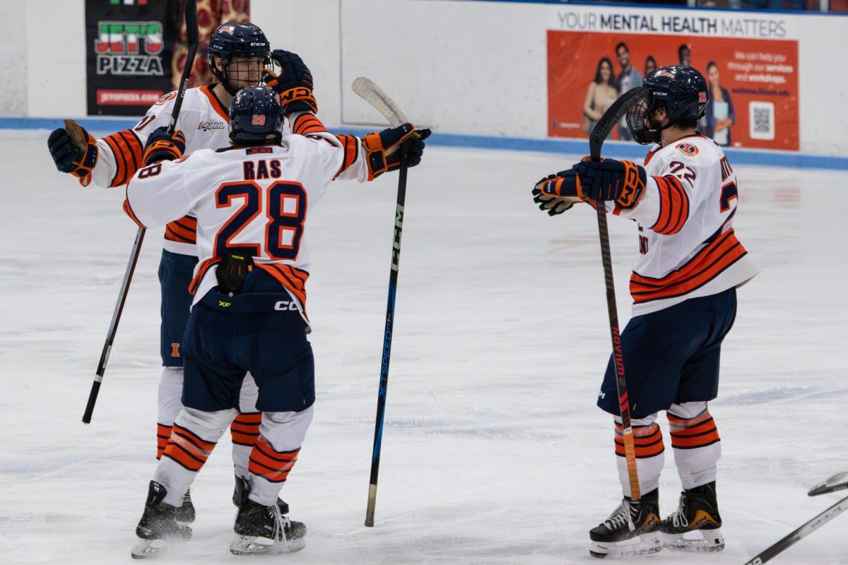 Sophomore forward David Ras and Carson Mitchell celebrate with a teammate during Illinois’ win over Rutgers on Nov. 1. 