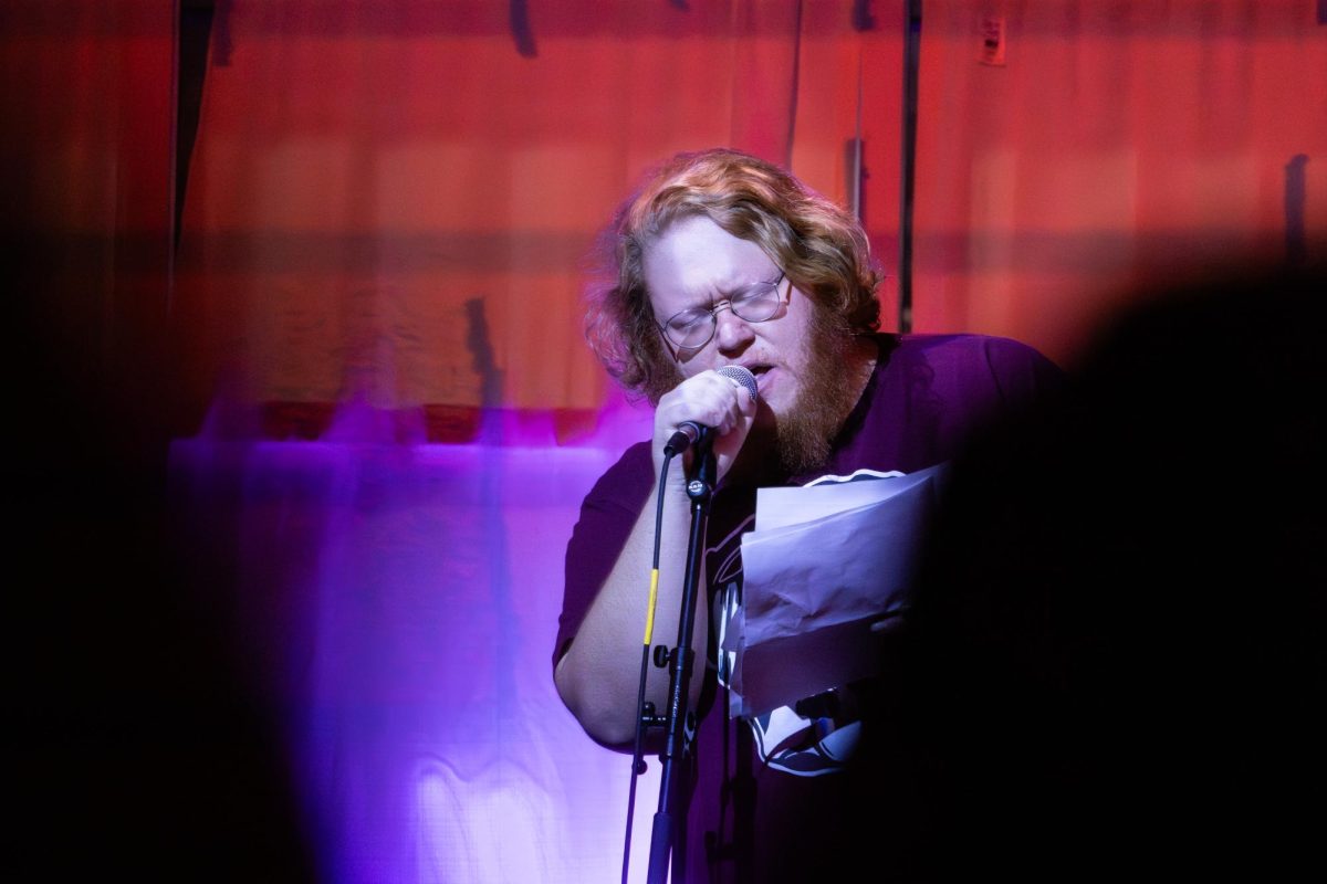 Graduate student David Foley delivers a poem at the VOICE: Graduate Student Reading event hosted at the Gallery Art Bar in Urbana on Nov. 12.