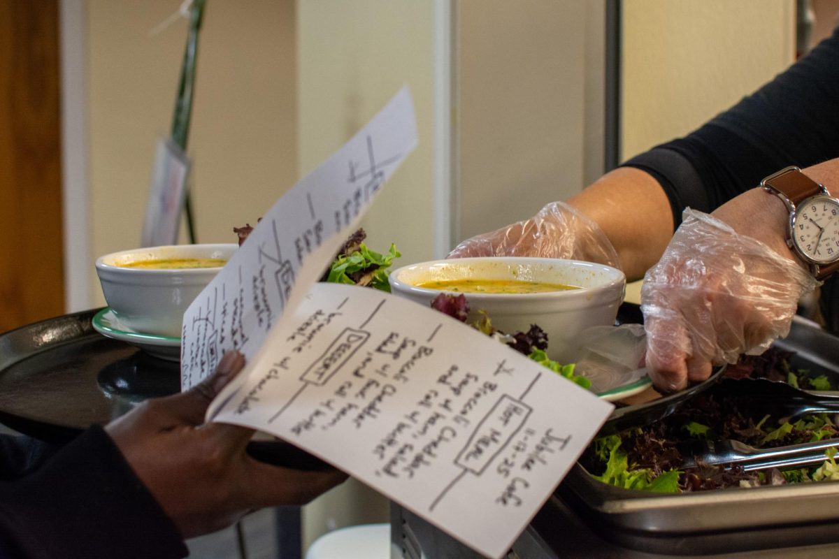 Volunteers at Jubilee Cafe, a weekly free dinner event hosted by the Community United Church of Christ on Sixth Street, serve up broccoli cheddar soup with ham, salad and a roll to community members on Nov. 17. The event happens every Monday night from 5:00 to 6:30 pm in the basement of the CUCC and offers fresh vegetables and pantry staples.