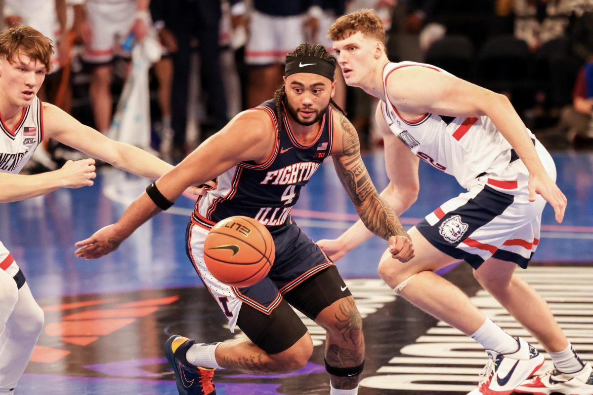 Illinois senior guard Kylan Boswell goes for the ball against UConn defenders at Madison Square Garden on Nov. 28.
