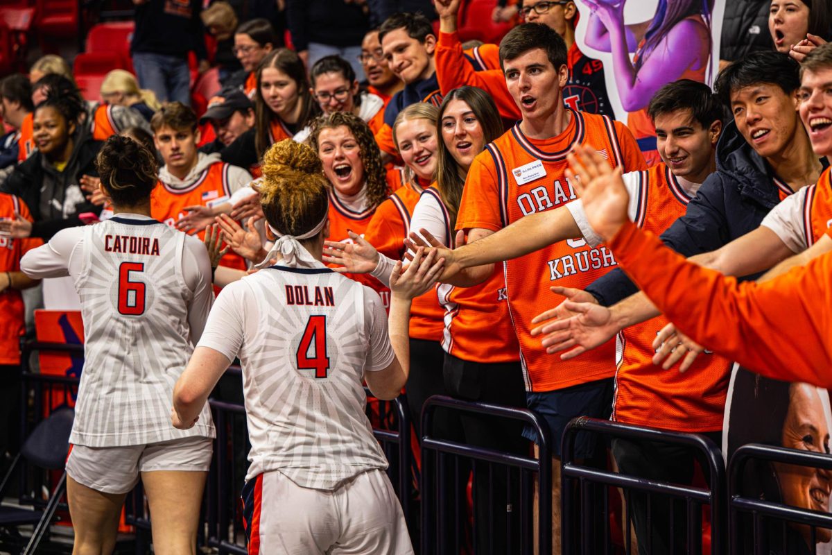Sophomore forward Irene Noya Catoira and junior guard Gretchen Dolan give high fives to the student section following an Illinois win over Indiana on December 6. Illinois won by a final score of 78-57.