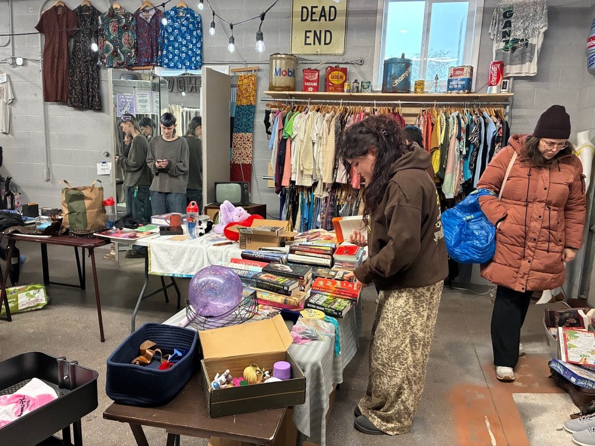 Patrons look at books and clothes at Resistance Threads during the Really Really Free Christmas Market on Dec. 10. The event was created to encourage people to shop at local businesses.