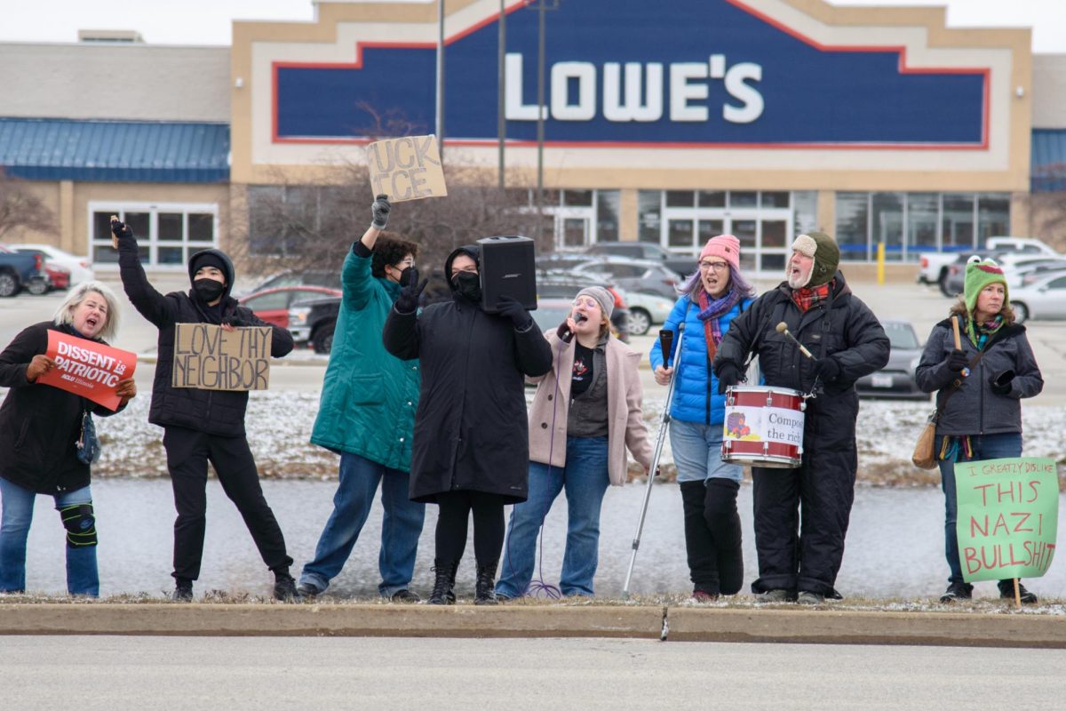  Community members gather along North Prospect on Sunday afternoon after a caravan through Champaign-Urbana. They hold signs and chant in protest of the Trump administration and U.S. Immigration and Customs Enforcement. 