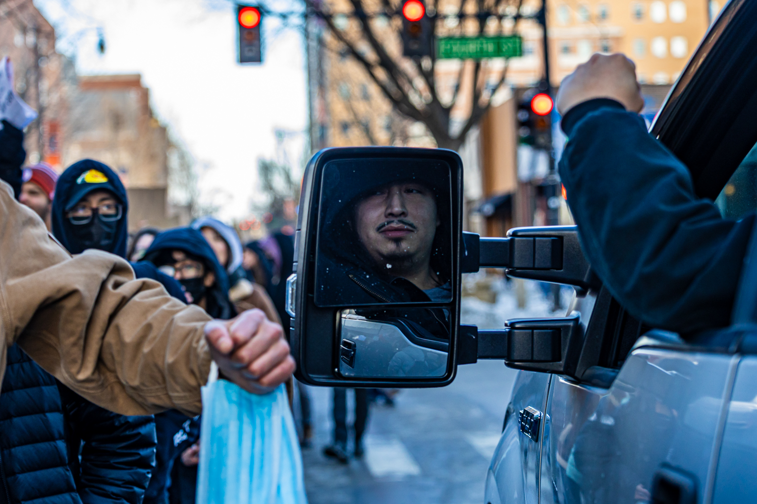 A man stopped in a truck on Green Street bumps fists with a protester as he waits for the crowd to pass on Jan. 30. The large crowd took up both lanes of the road, preventing most vehicles from getting through the protest.