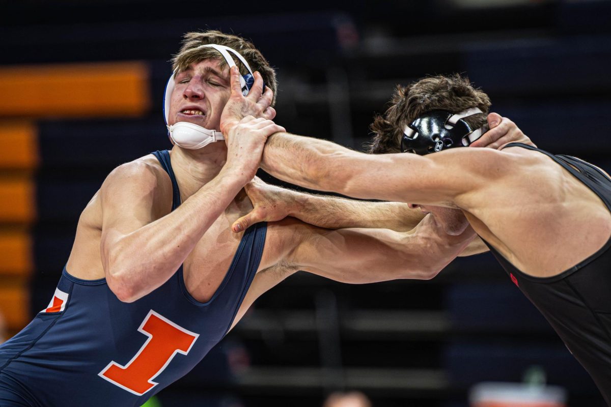 157-pound redshirt sophomore Kannon Webster gets a hand to the face during the Illinois vs. Rutgers duel on Jan. 24.