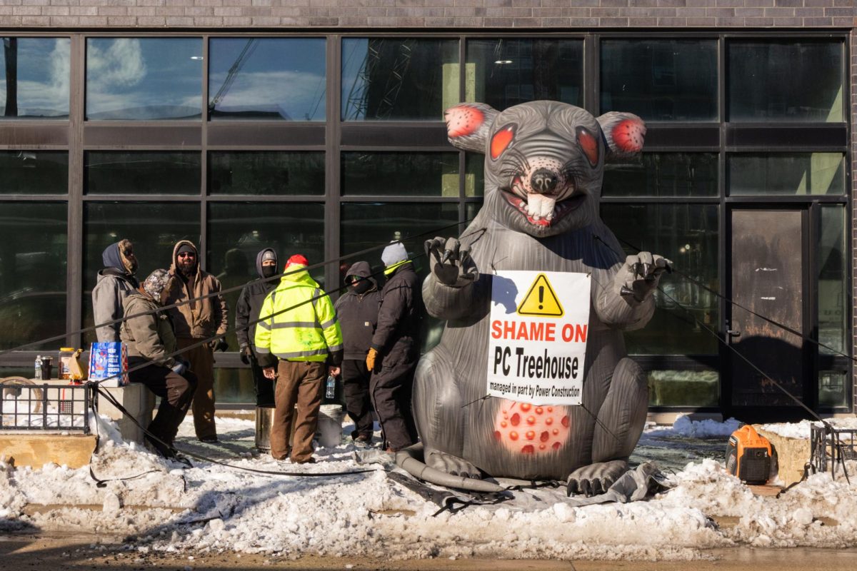 Members of the International Brotherhood of Electrical Workers Local 601 protest with a large inflatable rat outside of the high rise construction project at 201 E. Green St. on Jan. 28.