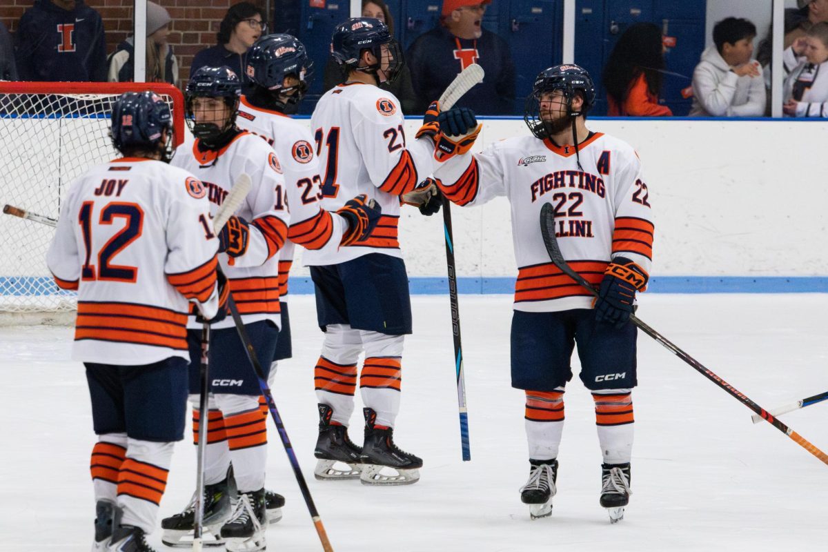 Sophomore forward Carson Mitchell gives fist bumps to his teammates after the end of the first period during the Nov. 1, 2025 matchup against Rutgers at the Illinois Ice Arena. 