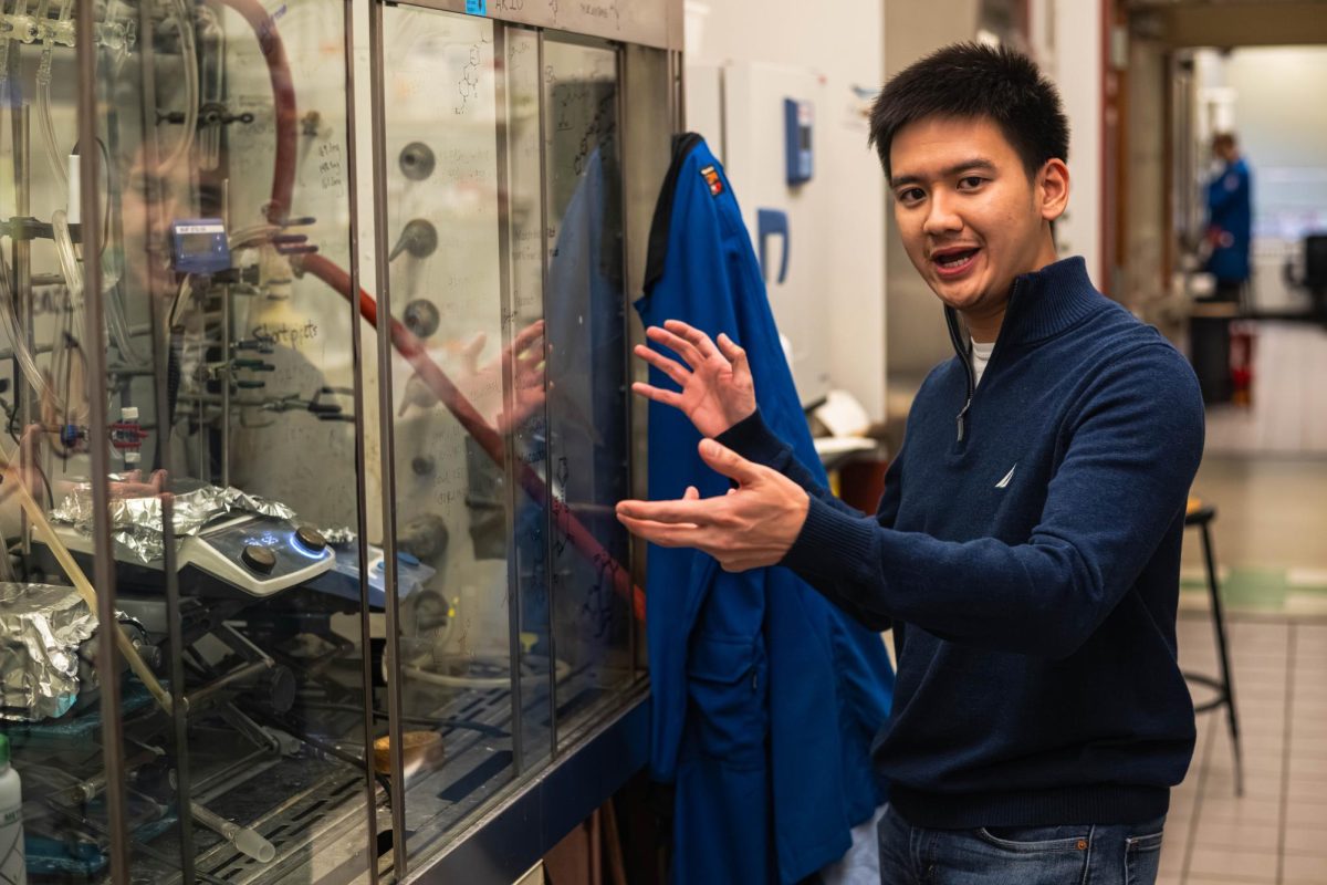 Kyle Abo, graduate student studying chemistry, gestures towards the fume hood located within his research lab at the Rogers Laboratory Nov. 13, 2025. Within this fume hood is where Raymond and other students use stir and hot plates to test sample’s reaction to heat, even elevating the temperature of some samples to as high as 160 degrees Celsius.