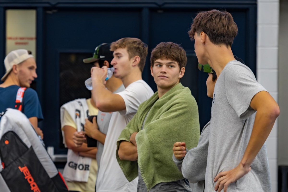 Illini tennis freshmen Adam Jilly (left), Sasha Colleu (middle) and Gabriel Debru (right) converse with junior Jeremy Zhang as senior teammate Kenta Miyoshi plays in the quarterfinals of the Champaign-Urbana Challenger on Nov. 14, 2025.