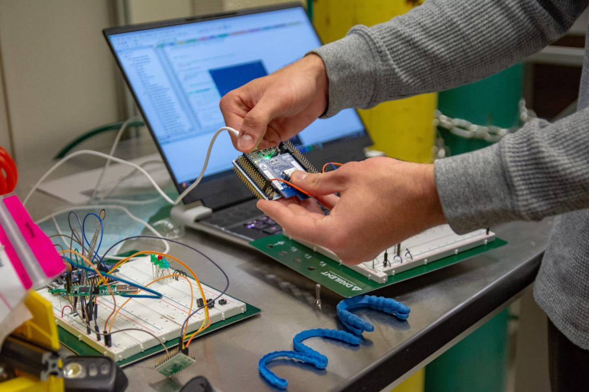 Oscar Kaplon, senior in Engineering, demonstrates how to collect data from a smart wireless retainer, which is part of a project in professor in Engineering Yang Zhao's Bionanophotonics Lab, on Nov. 18, 2025.